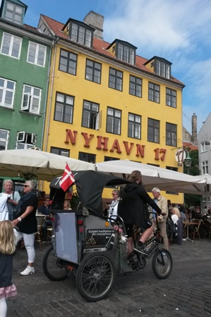 Theis rggar kunder med sin lådcykel i Nyhavn. I turen ingår även en CD med meditationsövningar.